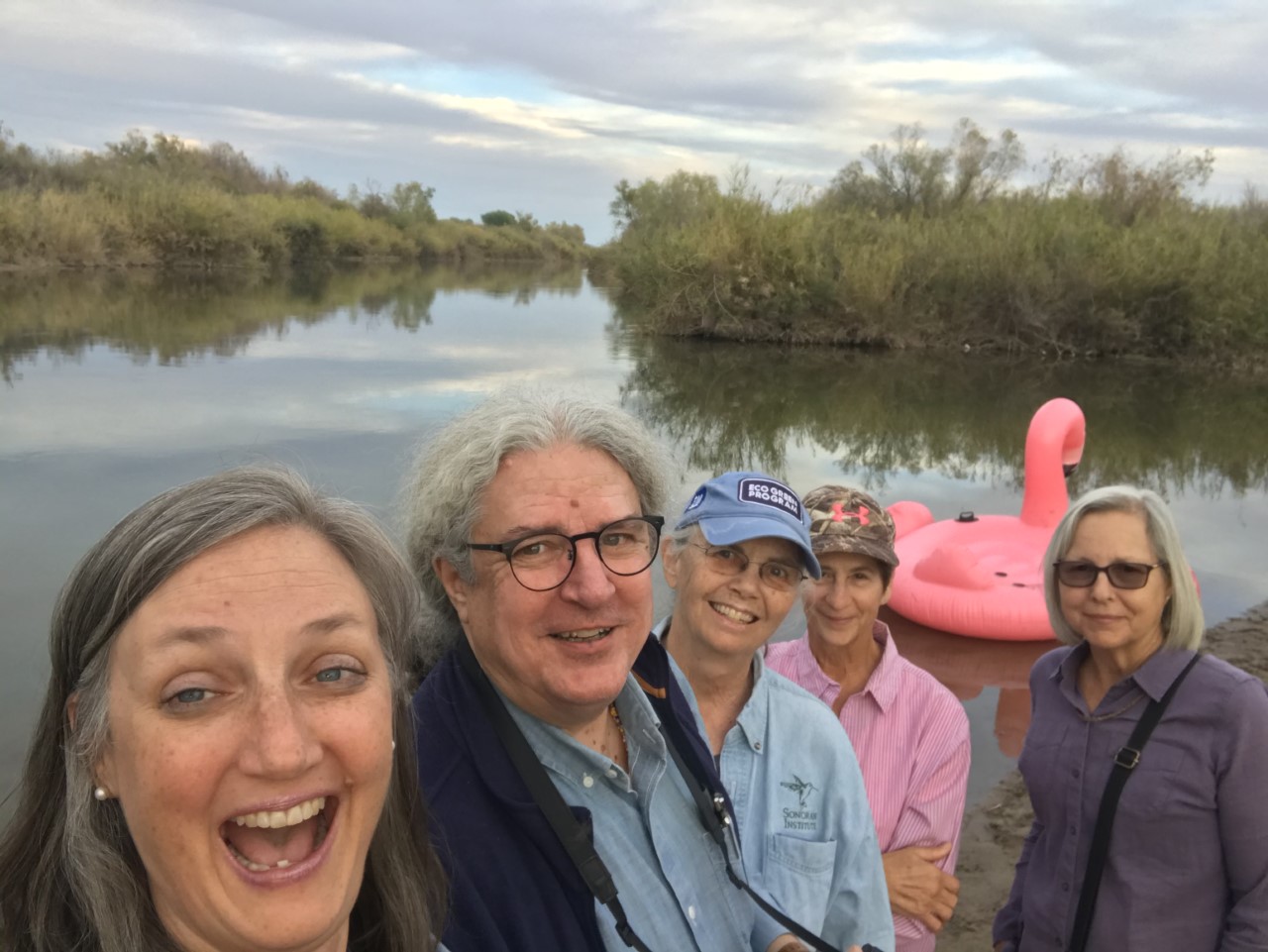 A group of people pose in front of the river