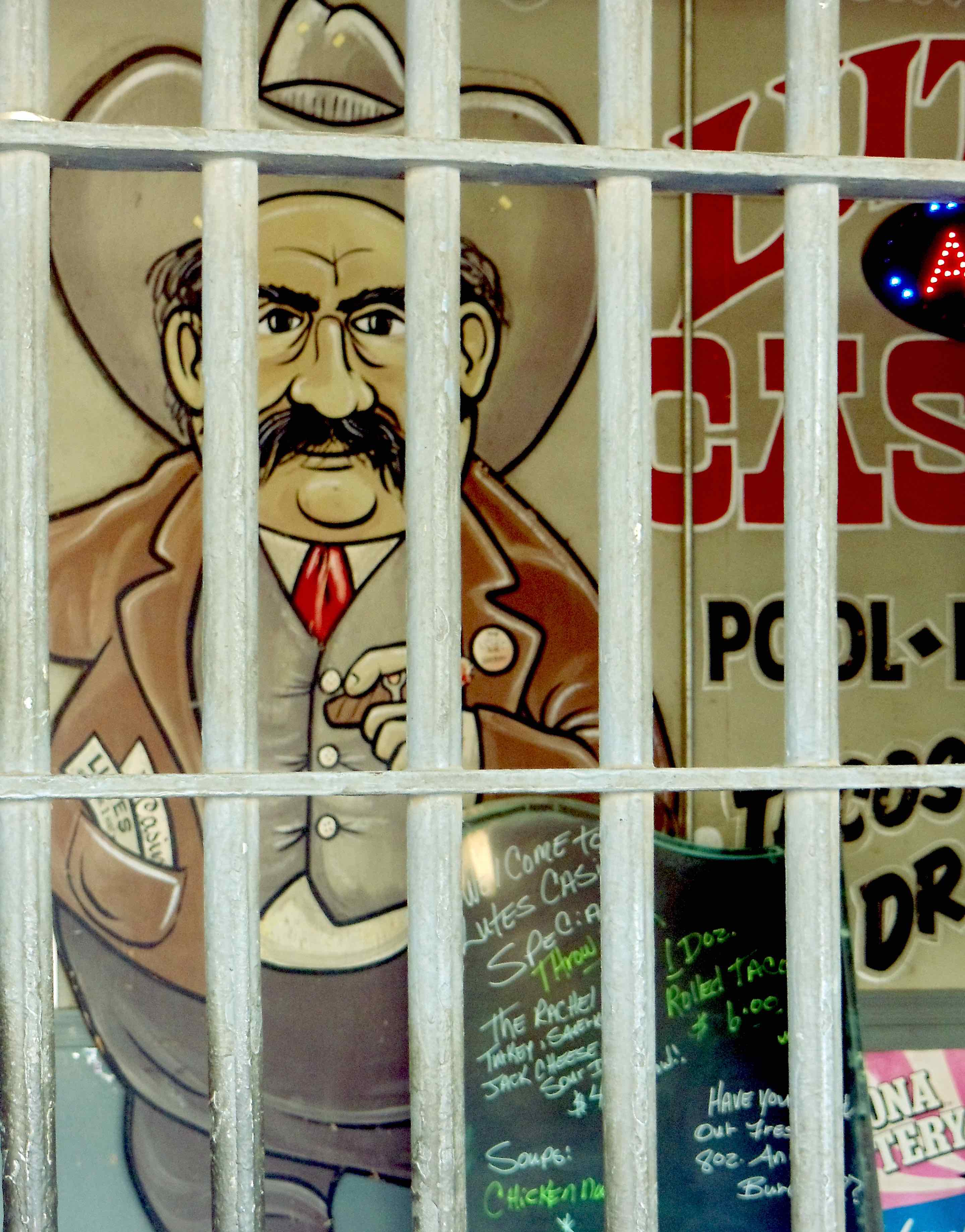 A classic art of a man with a big black mustache and cowboy hat is shown behind bars. The art is typically associated with Lutes Casino