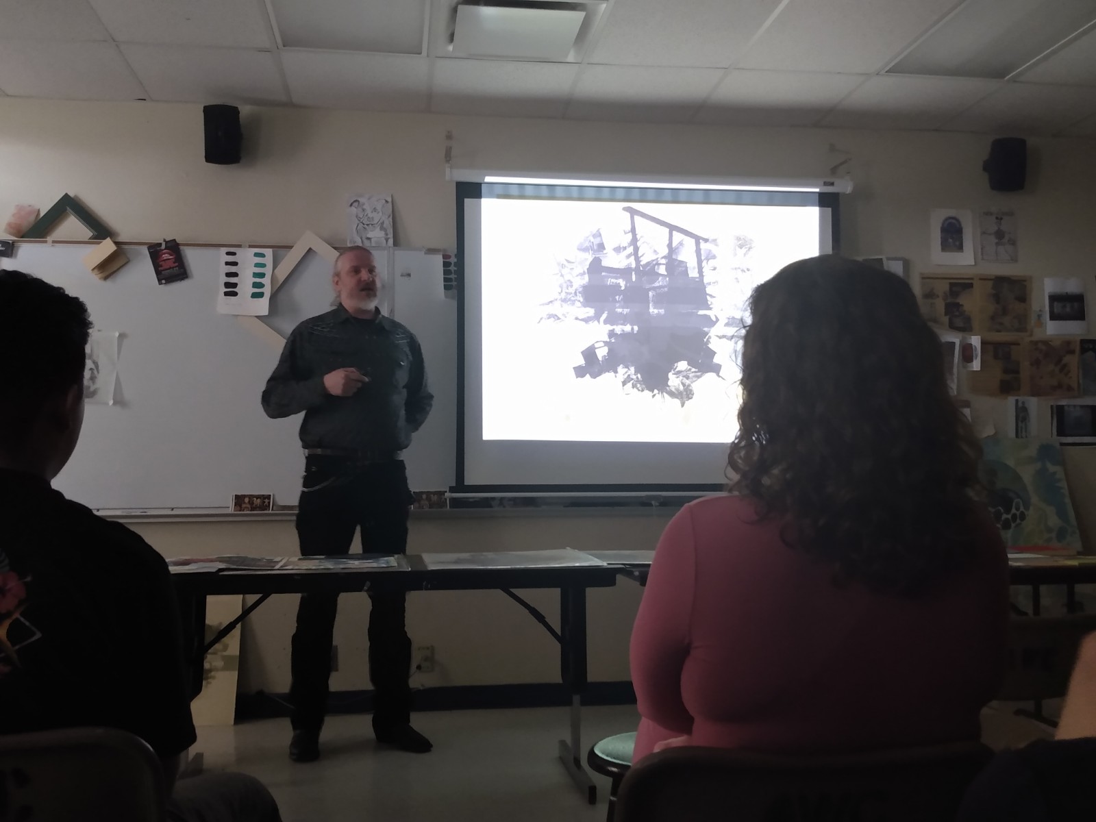 A man is presenting in front of a projector