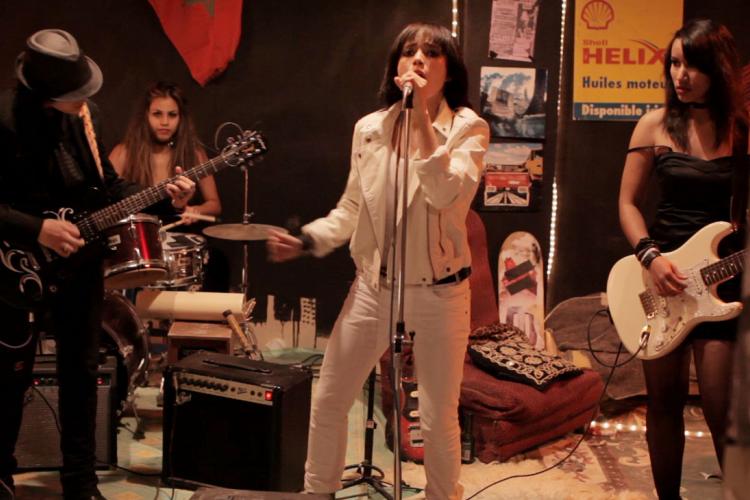 Traitors will play at the Historic Yuma Theatre on Main Street in December. Girl signing in front of her band.