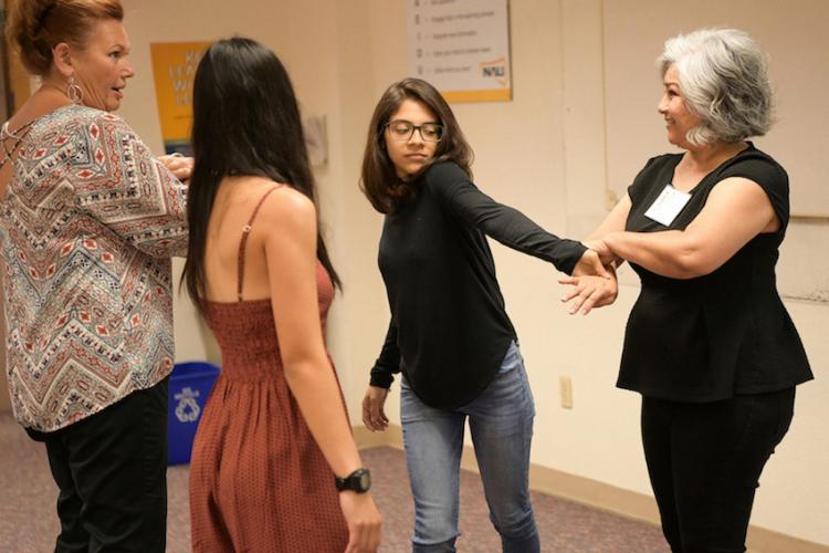 Instructor teaching group of women a self-defense tactic.