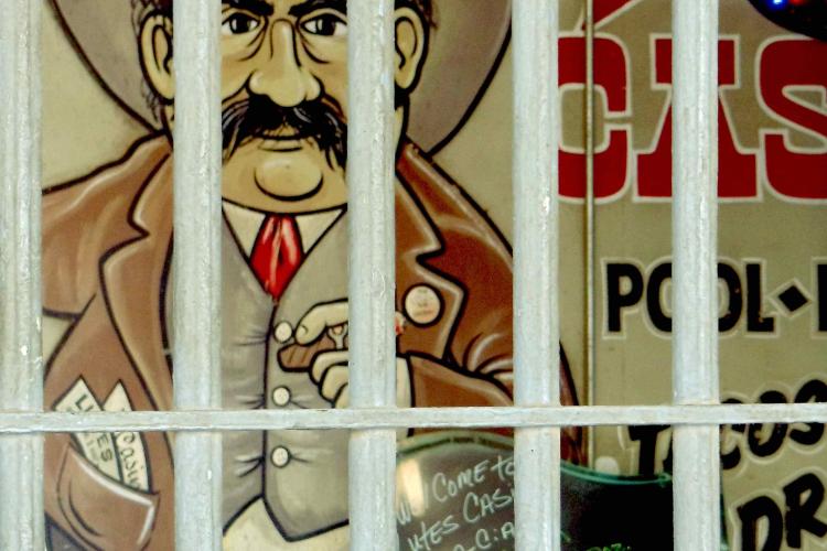 A classic art of a man with a big black mustache and cowboy hat is shown behind bars. The art is typically associated with Lutes Casino