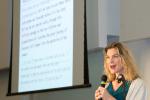 Female speaker in front of a projected screen